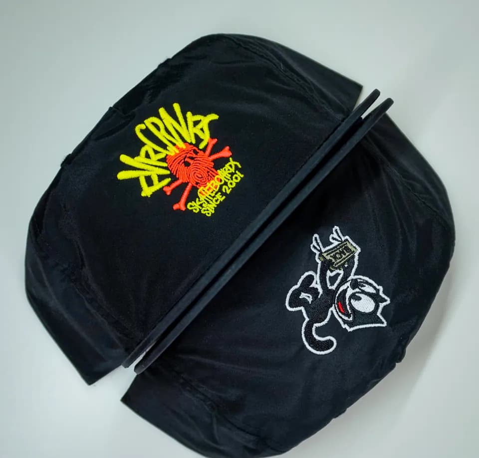 Black satin jackets embroidered with colorful lettering and white rose artwork