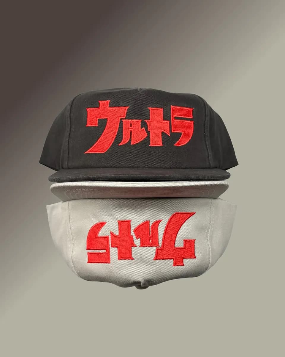 Black and cream caps embroidered with red Japanese lettering