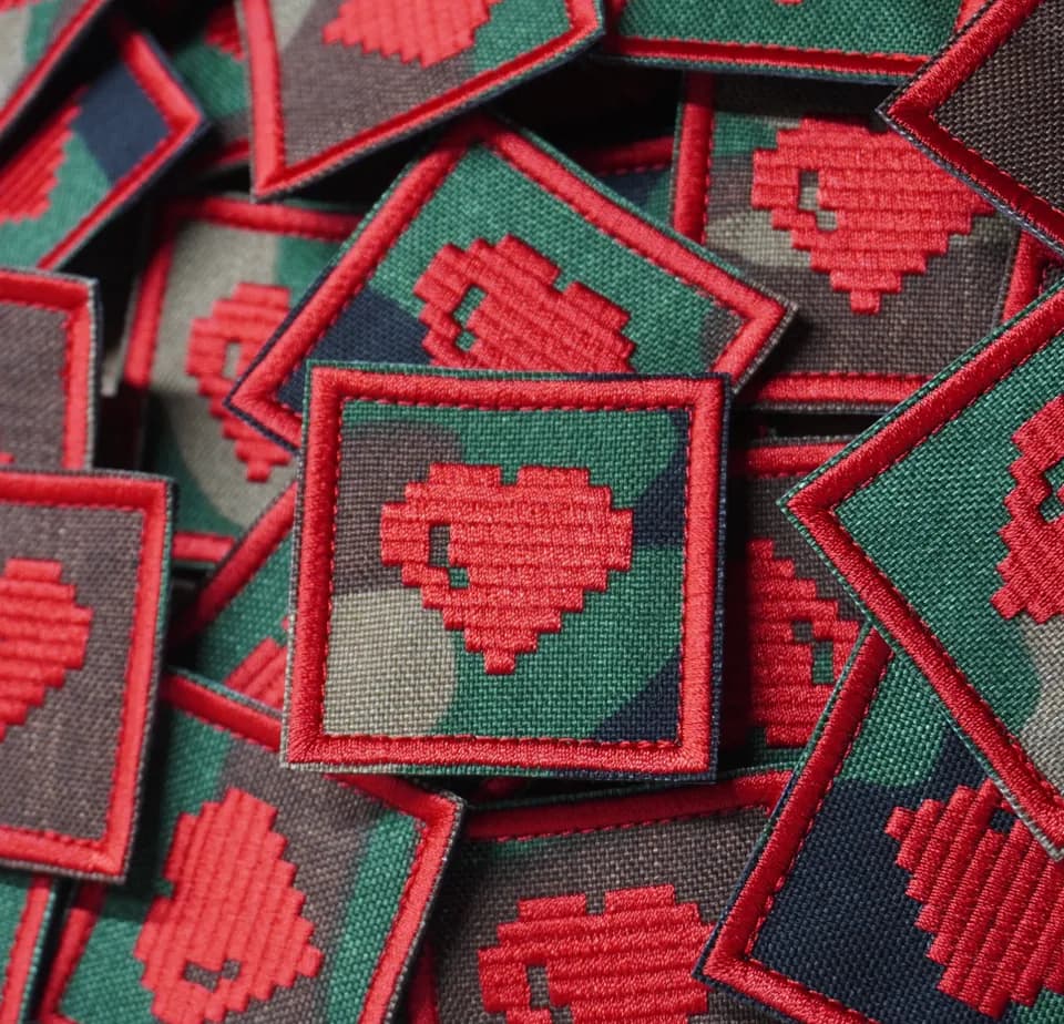 Gray patches embroidered with a red pixel heart and dark green borders