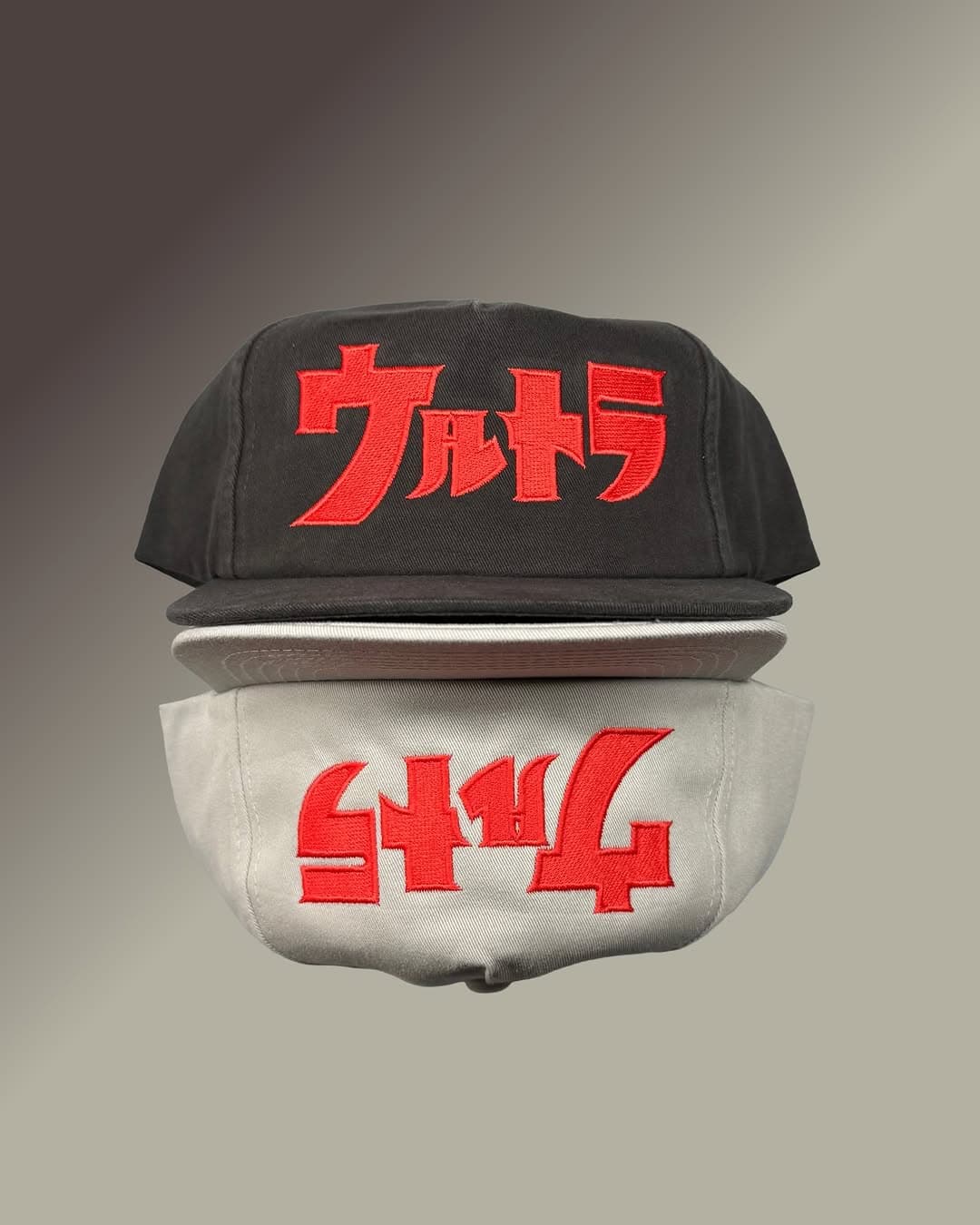 A stack of black, cream, and gray caps embroidered with red Japanese lettering