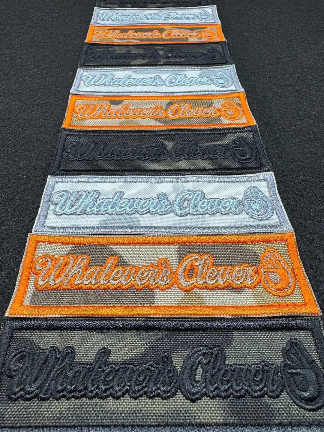 Rows of Whatevers Clever name patches in black, gray, and orange