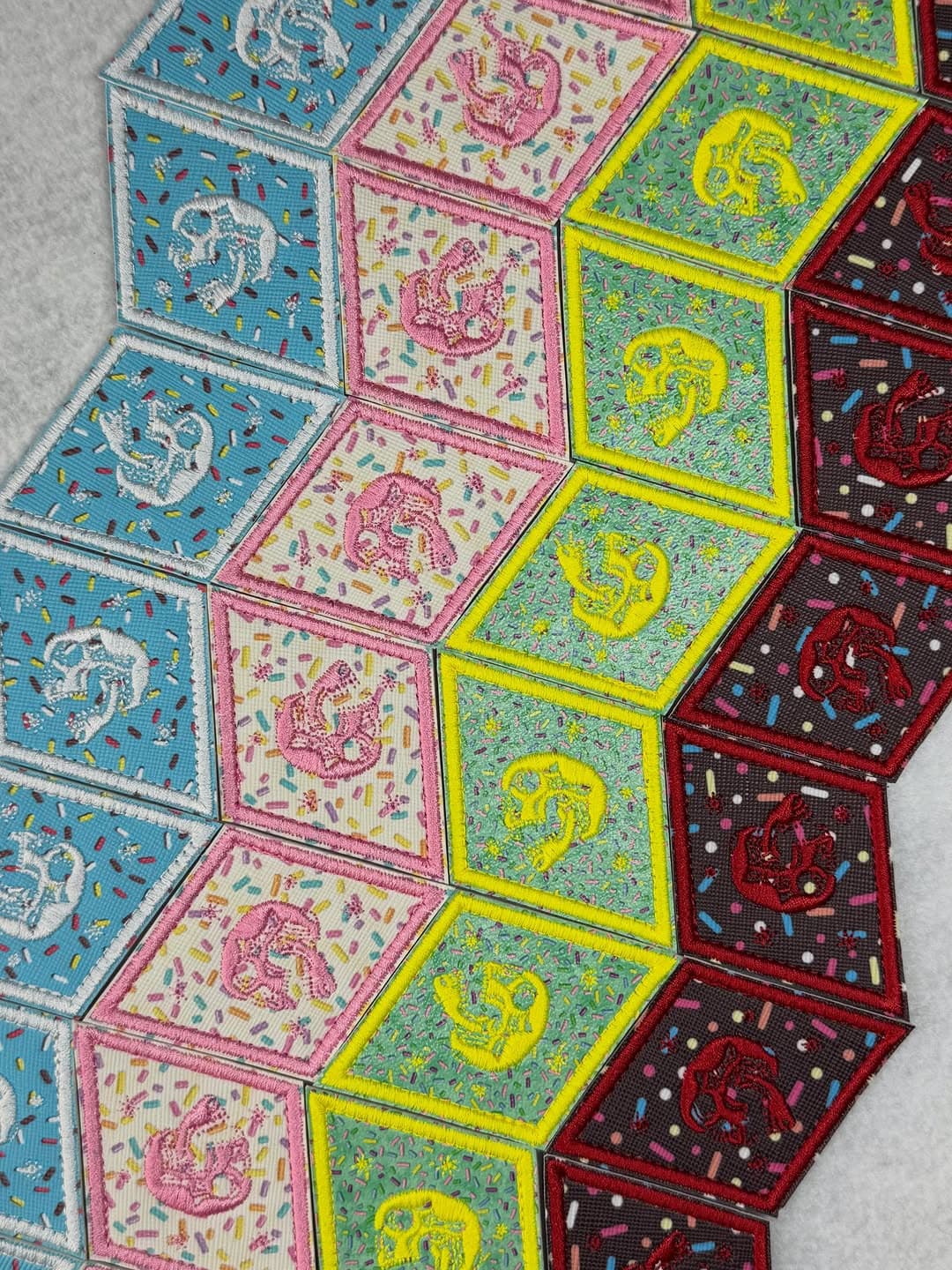Colorful square dinosaur skeleton patches on sprinkle-patterned backgrounds